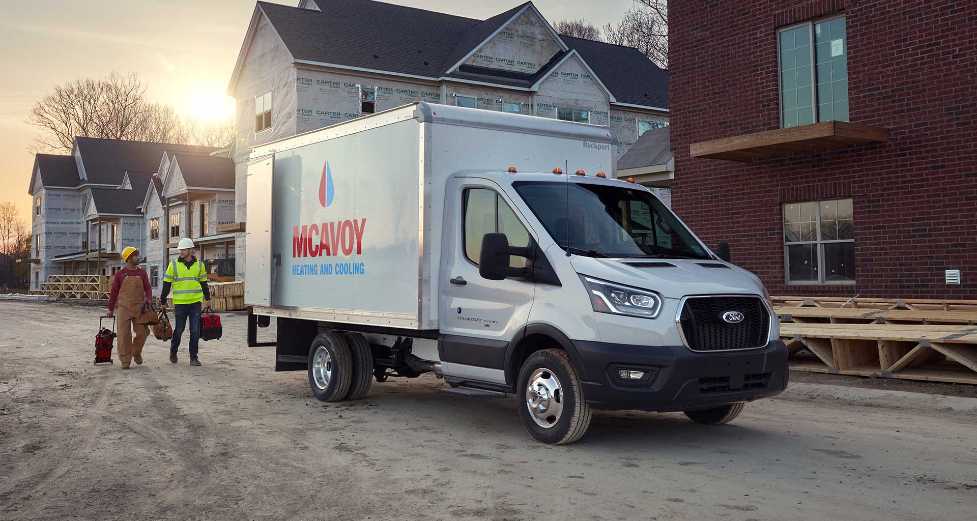 Workers from a heating and cooling company return to their 2020 Ford Transit chassis.