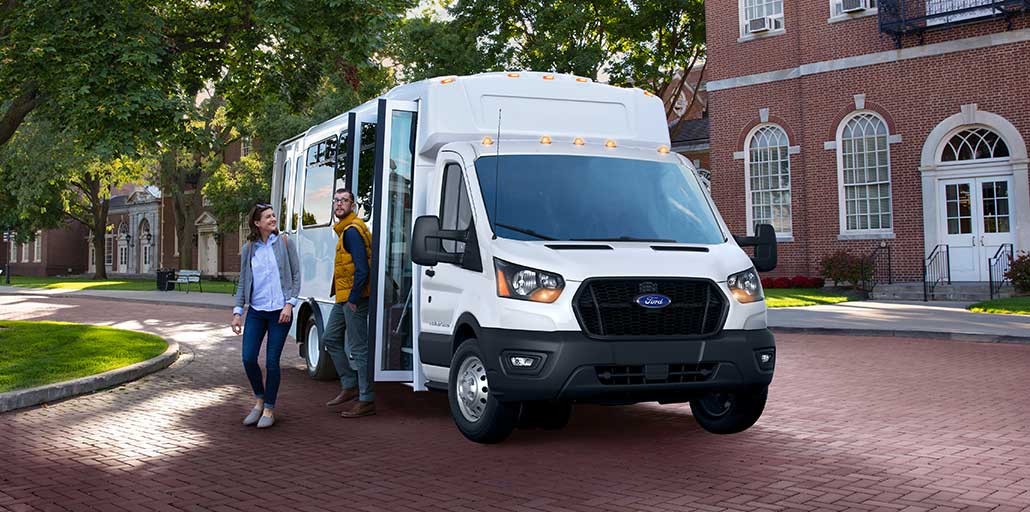 Two tourists exit a 2020 Ford Transit shuttle.