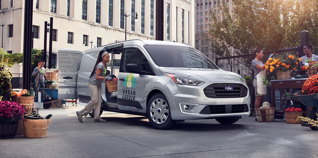 Ford Transit Connect with company logo and information printed on the doors.