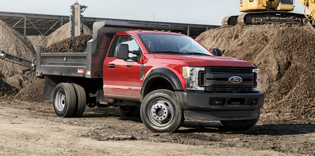 Ford Super Duty Chassis getting dirt dumped in the back of the vehicle