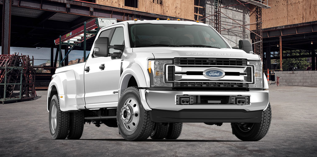 Ford Super Duty pickup with a ladder mounted on a rack.