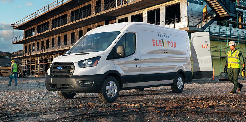 2020 Ford Transit at a construction site with company logo and information printed on the side.